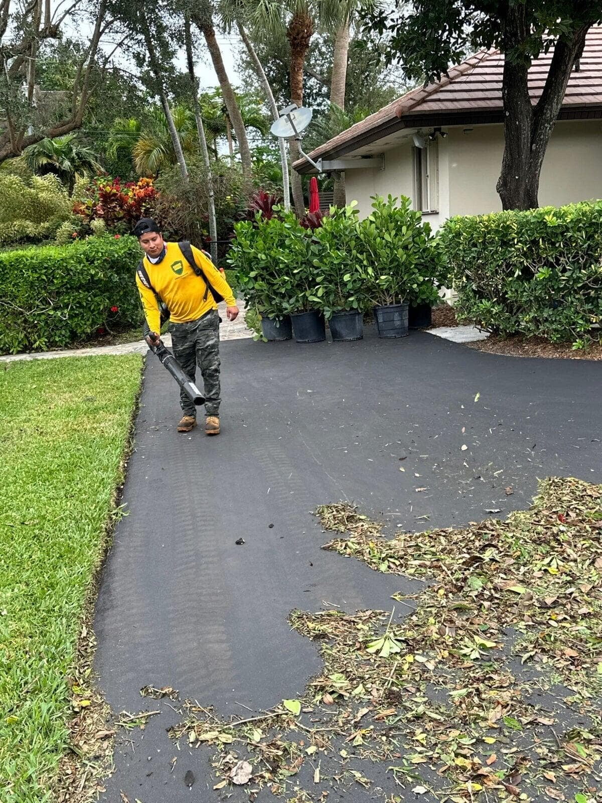 Nature’s Dream team member clearing landscape debris during residential maintenance
